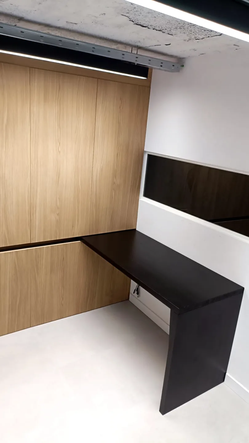 Mesa corredera de madera maciza lacada en negro integrada en el armario de roble de una sala de reuniones en Alicante