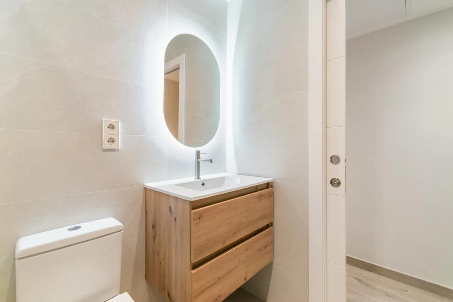 Baño reformado en Alicante con mueble de roble y espejo con luz LED